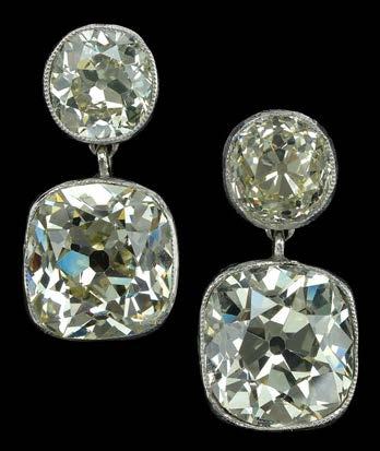 300-500 254 A PAIR OF DIAMOND EARPENDANTS, set with old-cut diamonds, each with a single-stone surmount, suspending a larger cushionshaped drop below, in white precious